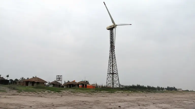 Tall windmill standing on the hard sand beach in Fraserganj.