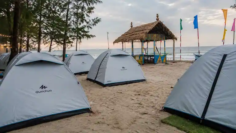 Basic beach tents set up on the sand at a Mousuni Island camp.