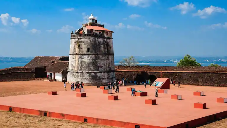 The historic Portuguese stone lighthouse and courtyard ramparts inside Fort Aguada.