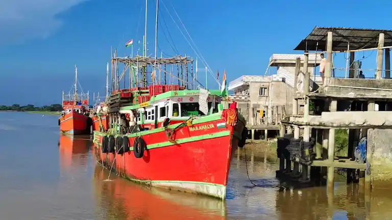 Colorful red and green deep-sea fishing trawler docked at the Balaramgadi Fishing Harbour jetty near Chandipur.