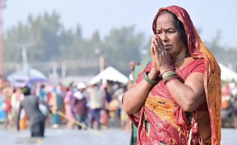 Older woman offering prayers during the holy bath at Gangasagar Sangam.