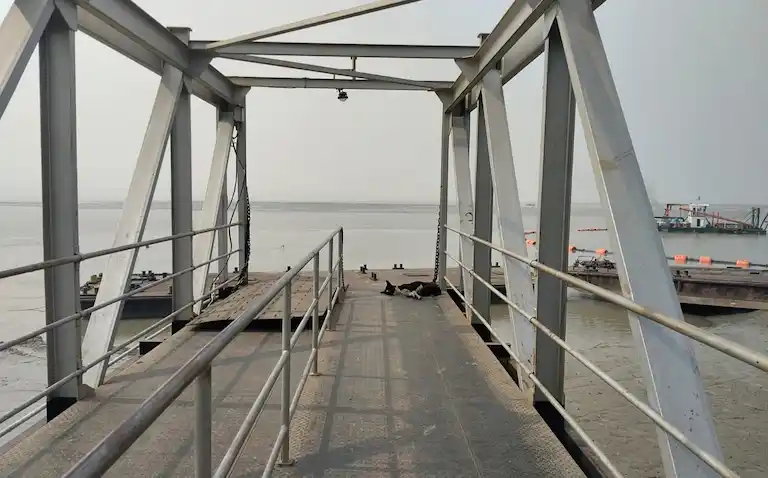 Steep metal walking ramp and muddy river banks at Kakdwip Lot 8 during low tide.