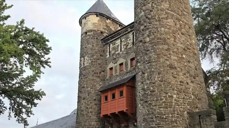 The medieval stone twin towers and red wooden balcony of Helpoort, the oldest city gate in Maastricht.