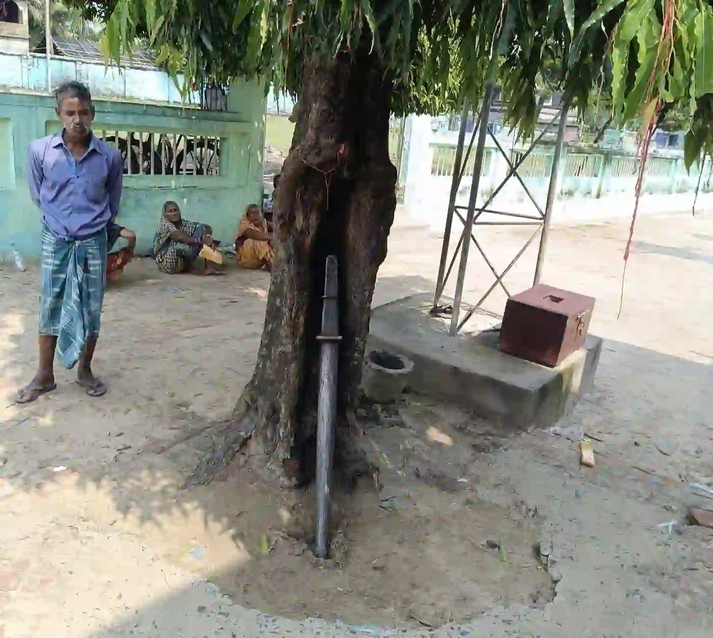 Sacred courtyard tree at Hijli Sharif with mannat threads and sword