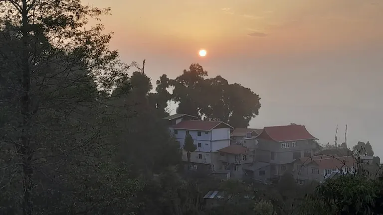 Golden sunset over the hillside homestays in the mountain village of Icche Gaon.