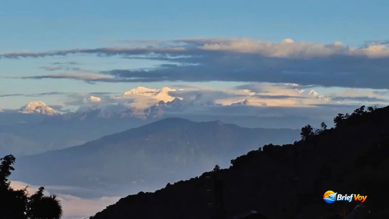 Snow-capped Mount Kanchenjunga peaks rising above clouds from Icche Gaon.