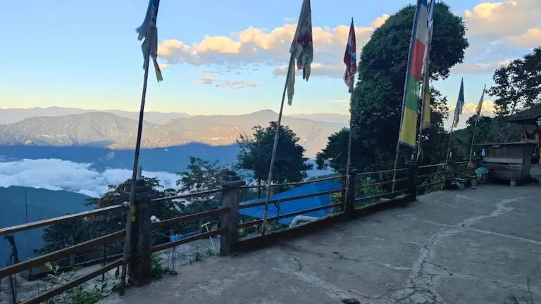 Himalayan mountains and valley clouds seen through prayer flags near Icche Gaon.