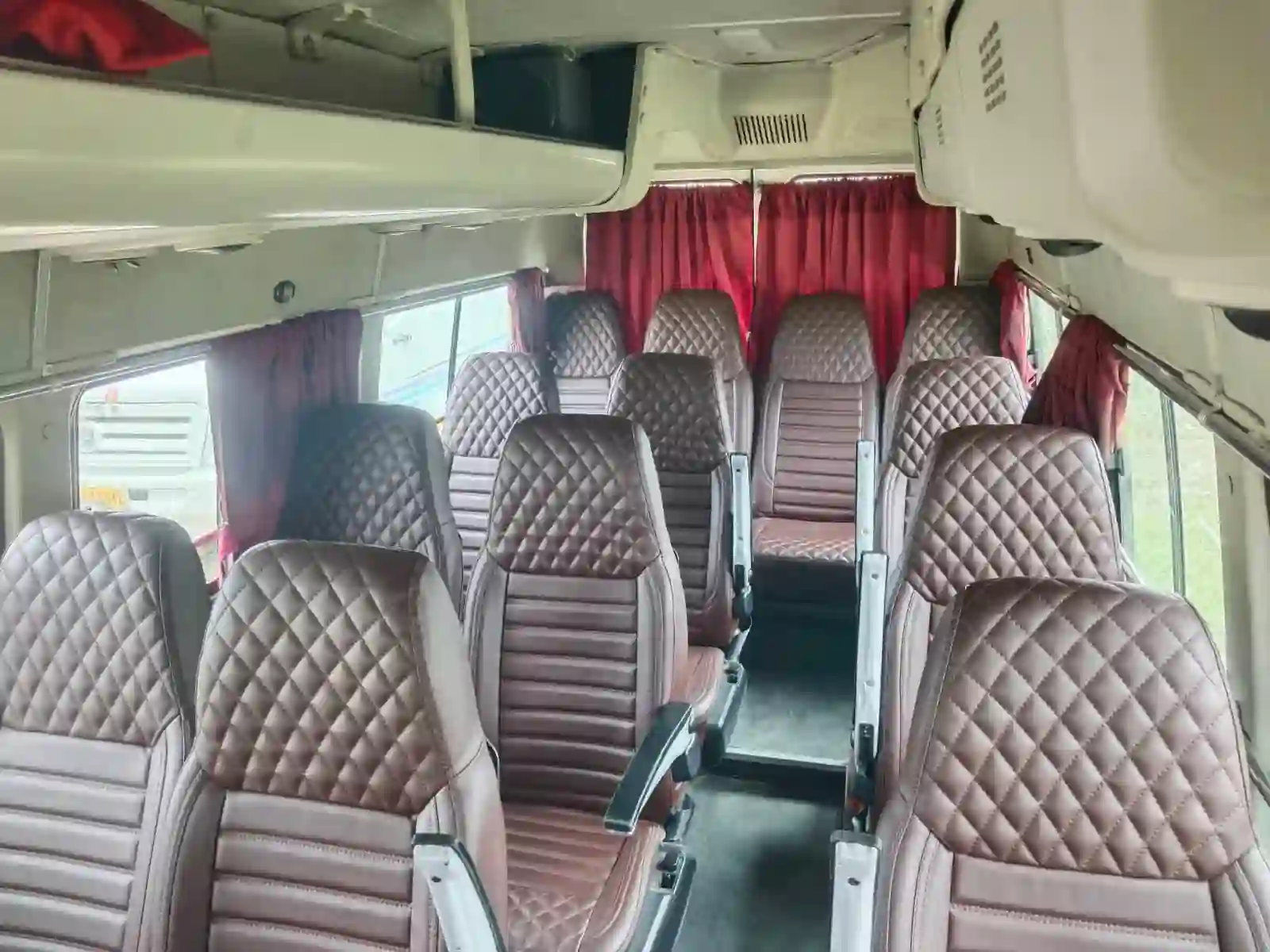 Diamond-stitched leather Maharaja pushback seats inside an AC Tempo Traveller in Kolkata.