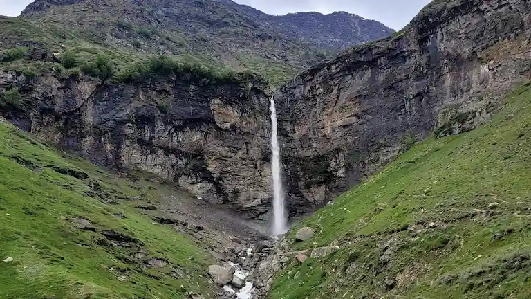 Sissu Waterfall flowing down a steep rocky cliff in Lahaul Valley