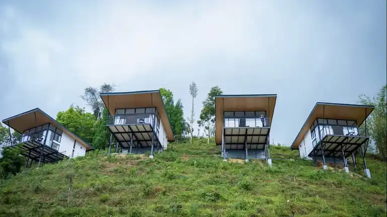 Modern hillside homestay cottages located on a green slope in the Sittong valleys.
