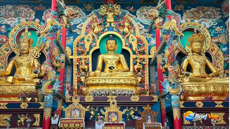 Three golden Buddha statues inside Golden Temple Coorg.
