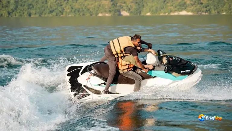 Tourist and guide riding a jet ski during Tehri Lake water sports.